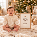 Duo Premier Noël Etika Paris : bébé en barboteuse ivoire à côté de son affiche « Mon premier Noël » personnalisée